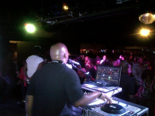 DJ performing on stage with a crowd dancing and enjoying the music